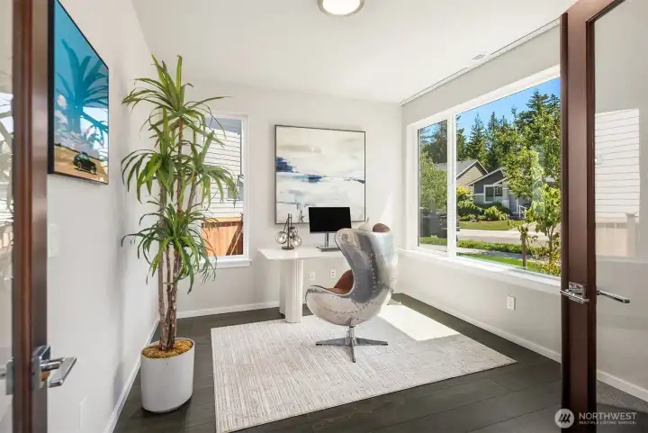 Bright private office with French doors, large windows, and a clean modern workspace overlooking the neighborhood.