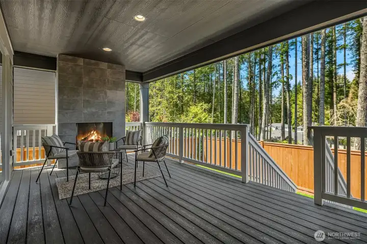 Covered outdoor room with fireplace creates a warm, sheltered space for year-round relaxing and entertaining.