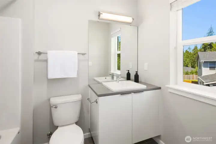 Private ensuite bath with clean modern finishes, natural light, and convenient direct access from the bedroom.