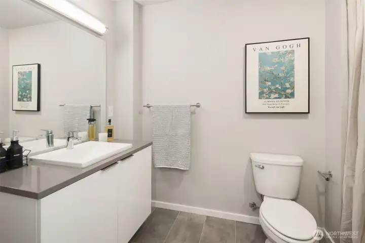 Clean, modern full bath with fresh finishes, vanity storage, natural light, and a shower/tub combination.