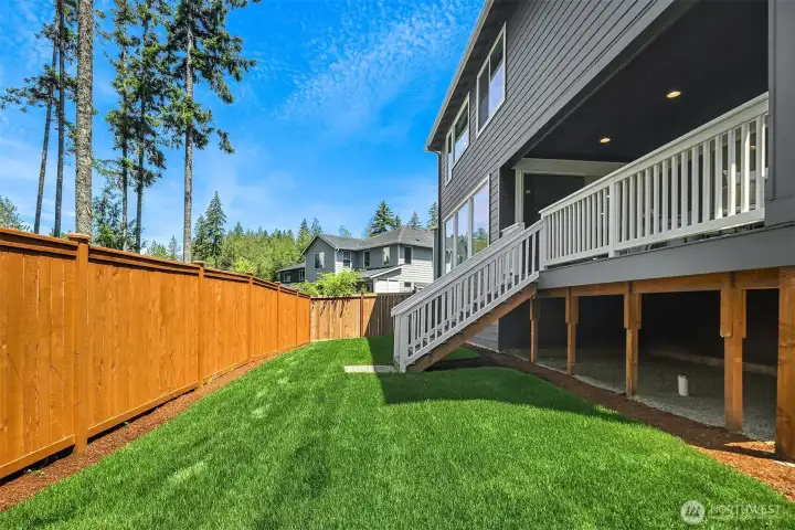 Elevated view showcases the mature forested backdrop and completed neighborhood setting, with natural privacy rarely found in nearby new construction.