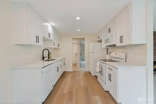 New kitchen features stunning white cabinets, new kitchen recessed lighting, quartz counters and luxury vinyl plank flooring. All appliances stay.