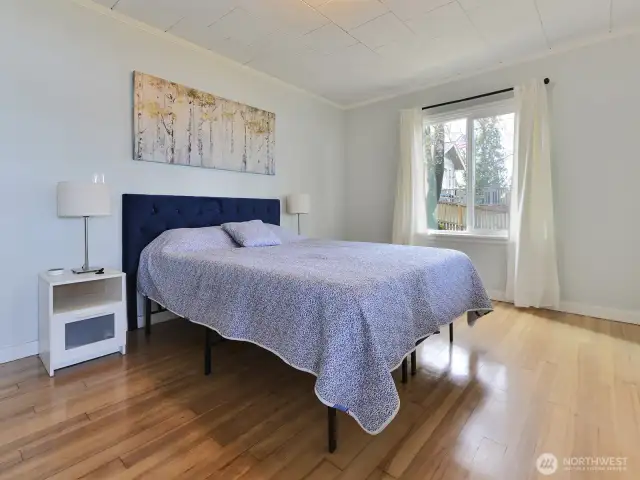 Primary bedroom with original hardwood floors and walk in closet, opens onto the sunporch