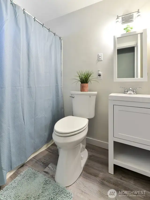 downstairs main full bath.  New floor, new vanity, new toilet, new light, new paint