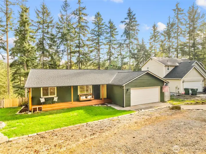 Charming single-level home surrounded by evergreens with a welcoming covered porch and beautiful setting.