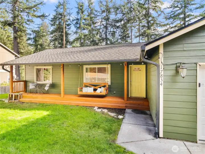 Enjoy the inviting front entry with a spacious covered porch and cozy swing—perfect for morning coffee or evening sunsets.