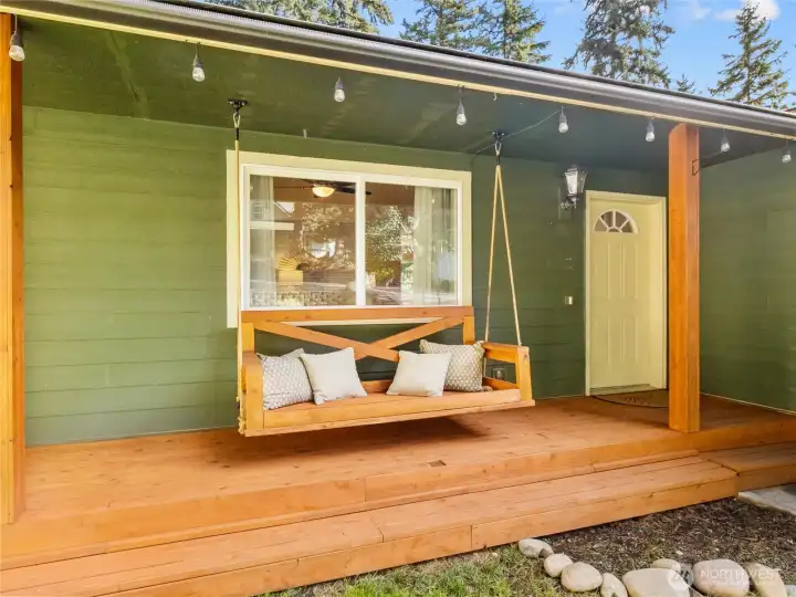 Covered porch with seating offers year-round enjoyment and a warm welcome for guests.