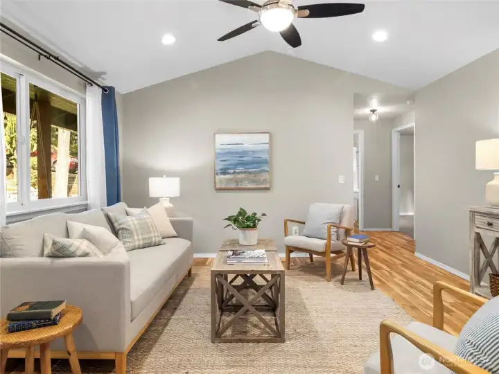 Bright and airy living room with vaulted ceilings, large windows, and open-concept flow.