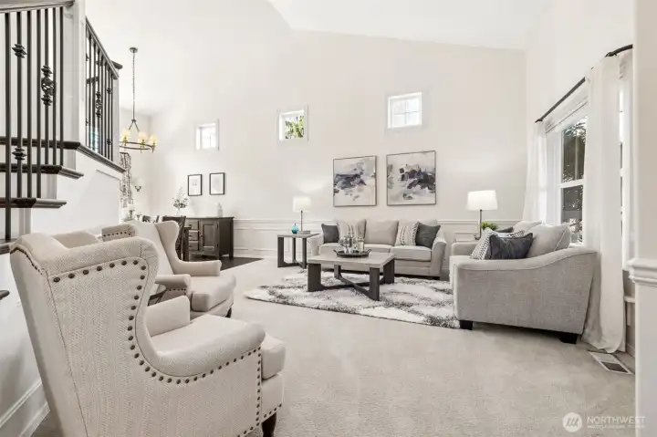 Impressive living room with soaring ceilings, high-set accent windows, and abundant natural light, offering a bright, open space ideal for both relaxing and entertaining.