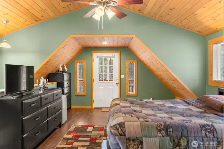Bright and airy Primary upper bedroom is comfortable and calming. Listen to the birds every day when you open balcony door.