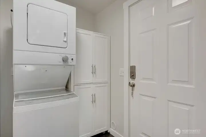 The washer and dryer, convey with sale, the cabinet on the right does not convey. The door goes to the attached two car garage.