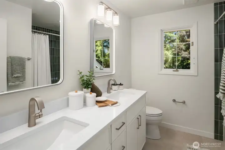 Remodeled bathroom with a pop of green tile to add a touch of fun color to your daily shower or bath.