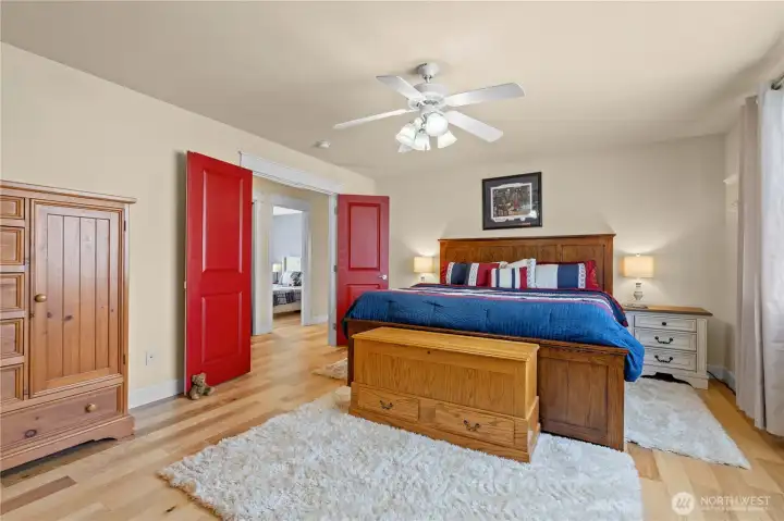 Primary Bedroom with Hardwood Floors, Double Door Entry, Ceiling Fan and En Suite Bath w/Walk-In Closet