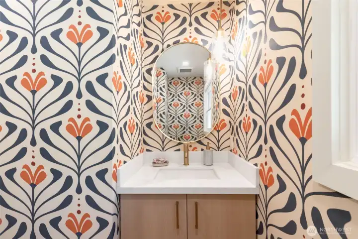 Powder room on main level with designer wallpaper. Powder room on main level with designer wallpaper.