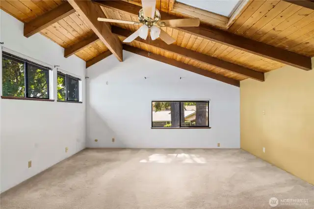 Upstairs loft is one large primary suite! More beams and pine ceilings w/ vaulted ceilings and skylights, really make this space inviting.