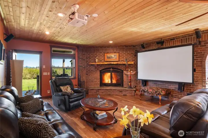 Light-filled living space anchored by a dramatic stone fireplace.