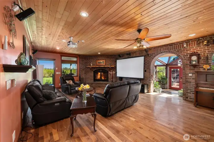 Light-filled living space anchored by a dramatic stone fireplace.