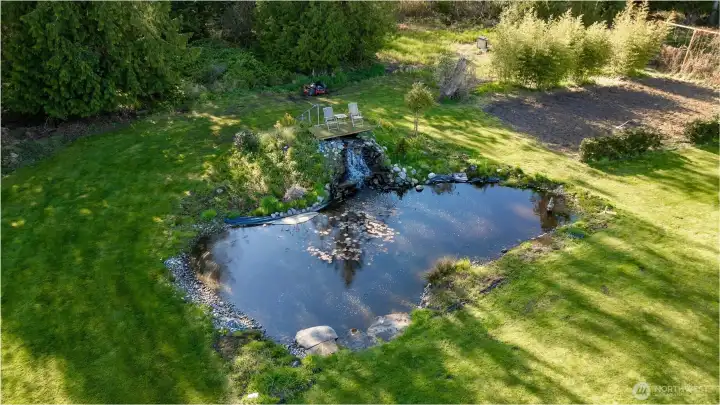 The pond as centerpiece, with adjacent grounds offering potential for a pickleball court or outdoor activity space.