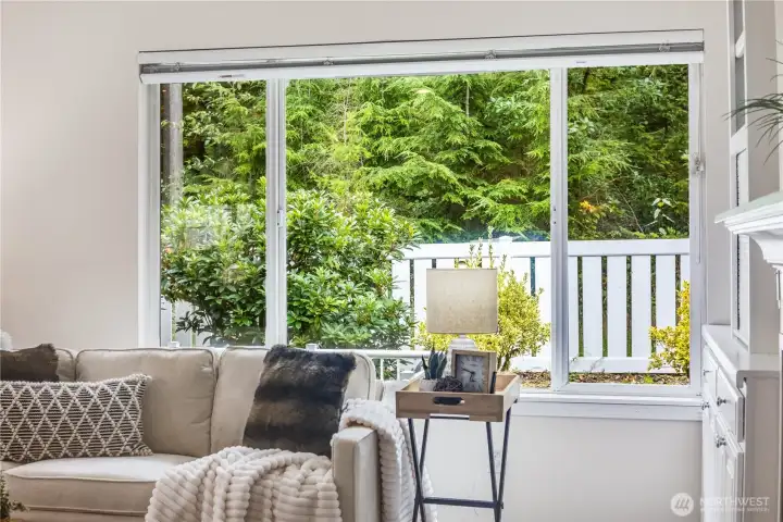 The greenbelt of mature trees behind the home offer privacy and peaceful views year-round from this main living area.