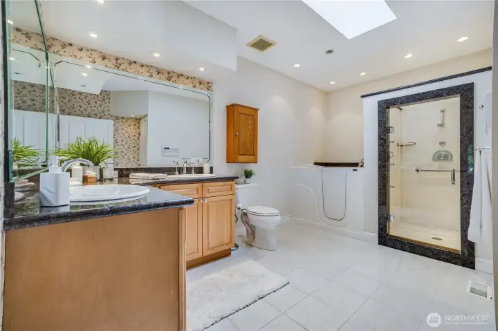 Featuring a tile floor, high end installations, and a generous vanity, the primary suite bathroom has many wonderful features.