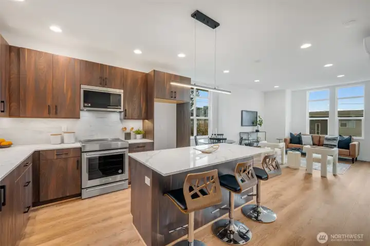 Seated island, quartz countertops, full height backsplash, stainless appliances.  Photos are of model home of similar floorplan. Color scheme and layout will vary.