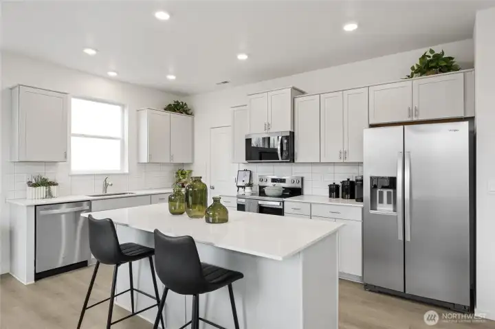 Kitchen with quartz countertops, full height backsplash, and soft close cabinets.  Pictures are for representational purposes only, colors and features may vary.