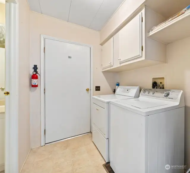 Laundry room with overhead storage.