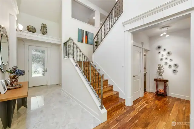 The view of the stairs to the second level. Hall bath to the right and front door view.