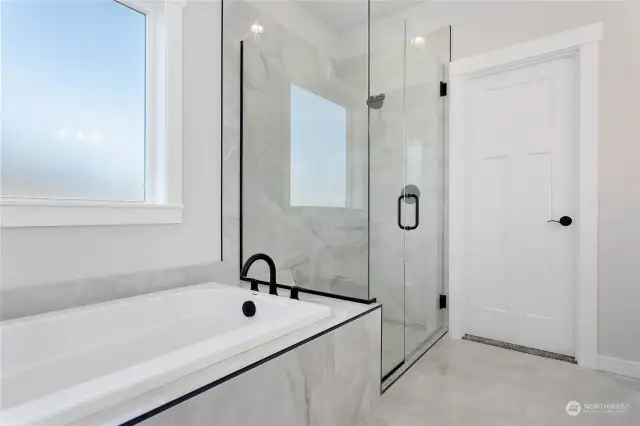 Large, tiled shower with a large soaking tub.