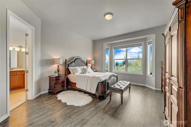 The primary bedroom looks out to the golf course and mountain views. Newer Luxury Vinyl Plank flooring.