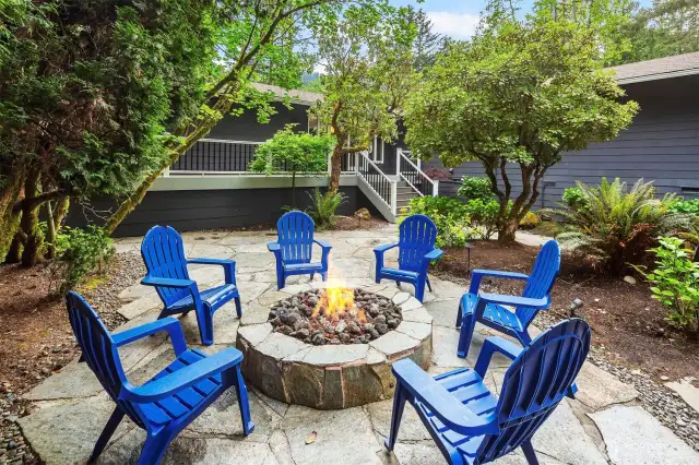 Effortless ambiance with gas-lit fire pit and tranquil outdoor setting.