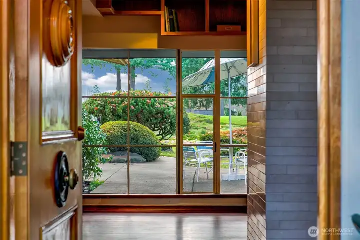 From the entry hall, a wall of commercial-grade steel windows frames the courtyard and fairway beyond. Warm woodwork and Venetian plaster draw the eye outward, creating a calm, seamless connection between the interior and the landscaped grounds.