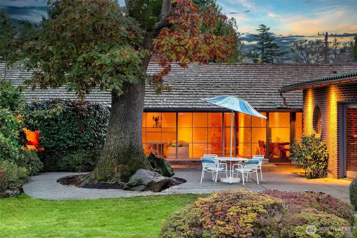 Evening settles gently over the lanai as the Fairway Residence glows from within. Framed by a heritage oak and lush gardens, this sheltered terrace invites lingering, offering a seamless connection between indoor comfort and the quiet greens beyond.