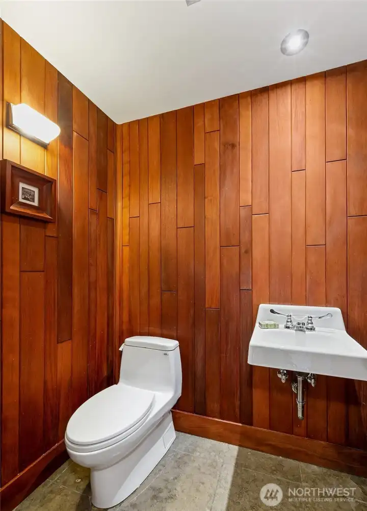 The powder room is wrapped in custom site-finished woodwork that brings warmth and precision to this compact space. Dornbracht fixtures and simple, well-made detailing give the room a quiet, modern character.
