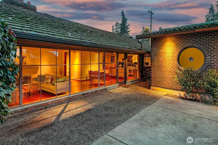 Completed in 2020, the freestanding bungalow stands as its own private pavilion, thoughtfully separate from the main house yet visually in tune with it. Floor to ceiling glass and cedar detailing create a warm modern profile, while the round oculus window becomes its defining architectural gesture, a sculptural focal point that brings in light and marks the bungalow as a place of retreat. The protected courtyard entry reinforces its sense of calm arrival and highlights the bungalow’s versatility as a guest suite, studio or sanctuary.