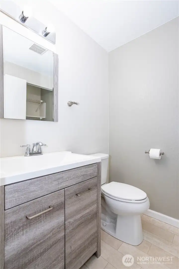 Updated bathroom with modern vanity, clean tile and bright lighting.