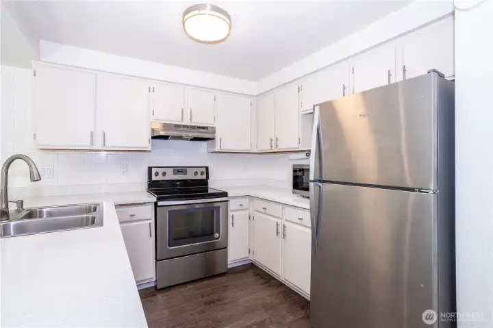 Kitchen showing full appliance package, ample counter space and modern finishes.
