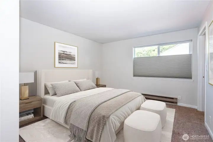 Primary bedroom with wide window and room for full-size furnishings.