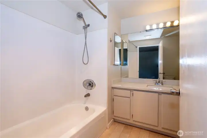 Updated bathroom with tub and modern vanity.