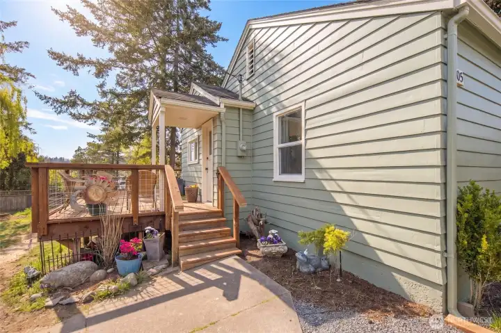 The charming 1940s cottage entrance welcomes you with fresh sage-green exterior paint and whimsical garden accents that set a warm, inviting tone. Perched above town, the home's elevated position captures the quiet residential character of this coveted Friday Harbor neighborhood.