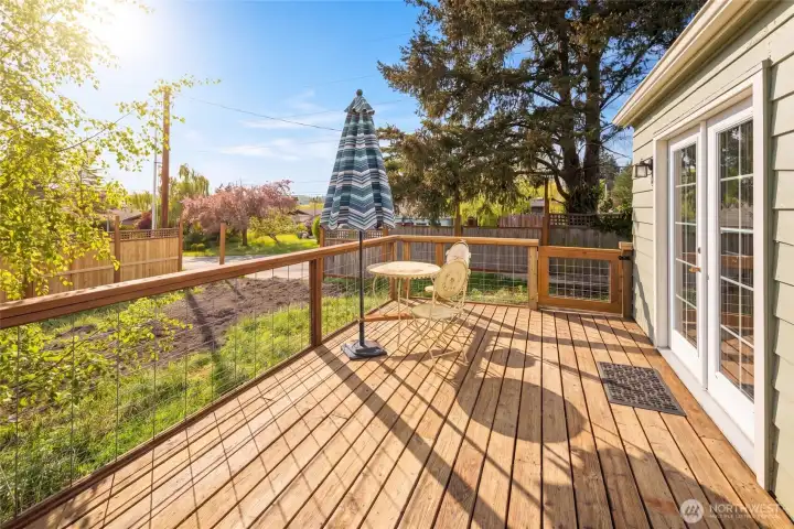 The expansive deck offers sweeping westerly views over the neighborhood treetops toward downtown Friday Harbor, perfect for soaking in San Juan Island's legendary sunsets.