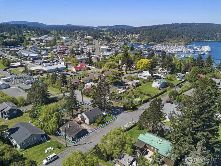 Looking west over the rooftops of Friday Harbor toward the marina and ferry landing, this elevated vantage point captures the incredible walkability of the property's location — shops, restaurants, the school, and the ferry are all just a short stroll away.