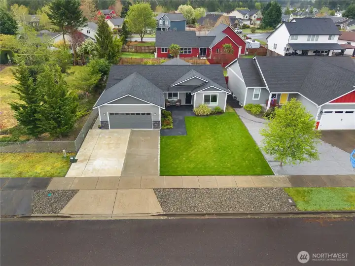 See the home’s clean curb appeal, broad front lawn, and attached garage from this aerial perspective.