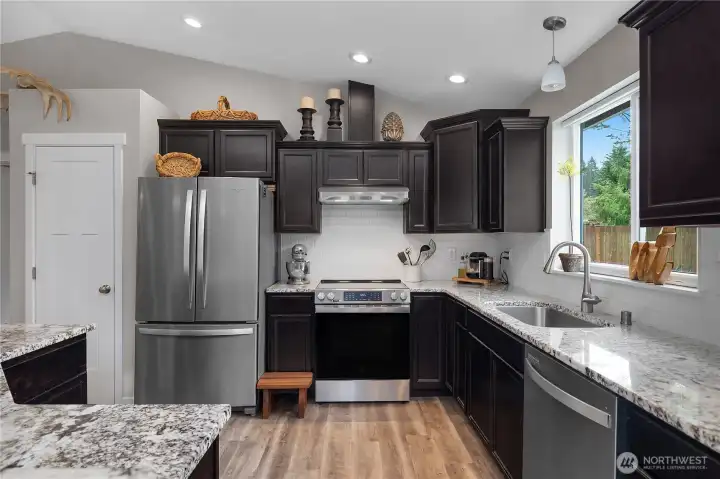 Well-appointed kitchen with stainless appliances, generous counter space, and backyard views from the sink.