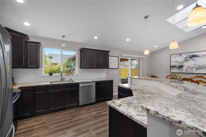 Prepare meals with ease in the open kitchen featuring abundant counters, bright lighting, and direct flow to the dining area.