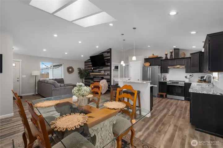 Appreciate the open great room design with skylights, vaulted ceilings, dining space, and a stylish kitchen connection. Appreciate the open great room design with skylights, vaulted ceilings, dining space, and a stylish kitchen connection.