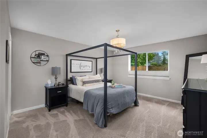 Spacious primary bedroom featuring soft carpet, neutral tones, and generous natural light.