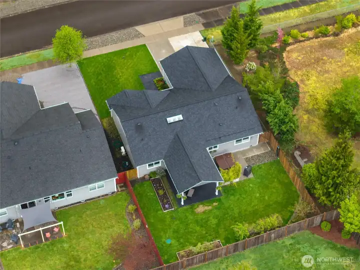 Appreciate the home’s private backyard orientation with lawn space, patio areas, and mature greenery along the property line.