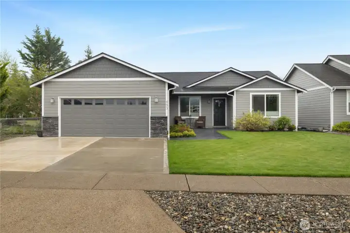 Clean, well-kept exterior with fresh landscaping, generous driveway parking, and a stylish front elevation.