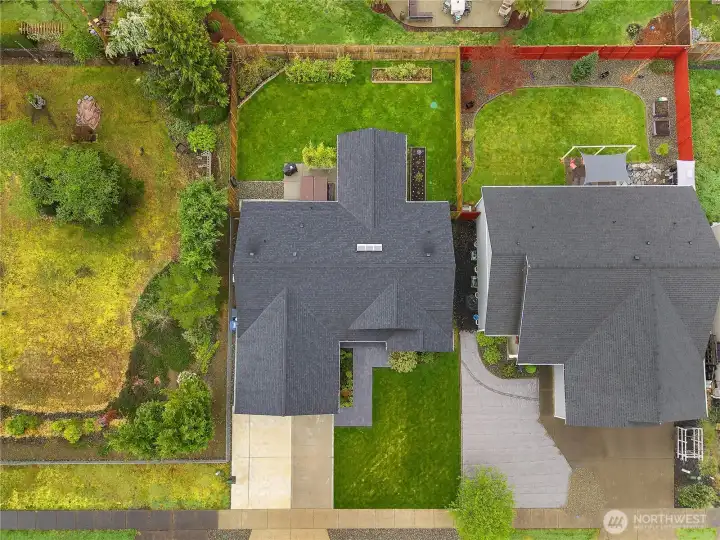 Full property layout with fenced backyard, covered patio, lawn space, and established garden beds.